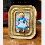 Tableau ALICE, figurine Playmobil en robe bleue et tablier blanc dans un cadre doré sur fond fleuri