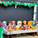 Scène de La Cène en figurines Playmobil autour d'une longue table garnie de fruits, pichets et chandeliers dorés