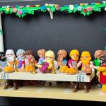 Scène de La Cène recréée en figurines Playmobil autour d'une longue table garnie de pains, fruits et carafe