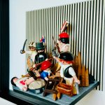 Détail du tableau La Liberté guidant le peuple en figurines Playmobil, barricade, fusils et fond rayé noir et blanc
