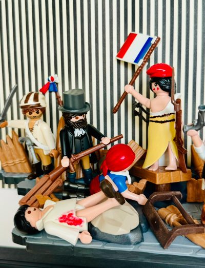 Scène La Liberté guidant le peuple recréée en Playmobil, femme au bonnet rouge brandissant le drapeau tricolore