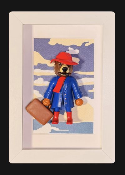 Tableau Paddington, figurine ours au chapeau et bottes rouges, manteau bleu et valise, cadre blanc 10x15 cm