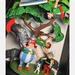 Détail du tableau ASTÉRIX et OBÉLIX avec figurines Playmobil, sanglier, chien blanc et Romains sous un arbre