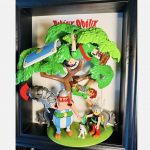 Tableau Astérix et Obélix, figurines Playmobil sous un arbre avec Idéfix, sangliers et Romains, cadre noir