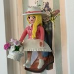 Figurine Playmobil blonde en tenue rose et chapeau blanc avec panier de fleurs, tableau Cowgirl