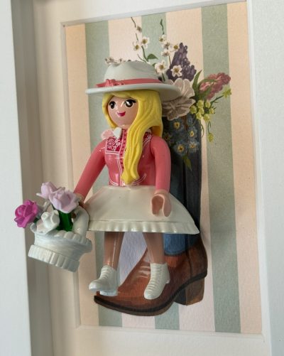 Figurine Playmobil blonde en tenue rose et chapeau blanc avec panier de fleurs, tableau Cowgirl