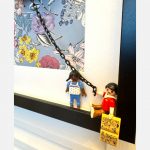 Détail du tableau J'AI RÊVÉ : deux figurines Playmobil sur une balançoire à chaîne devant un fond floral bleu encadré