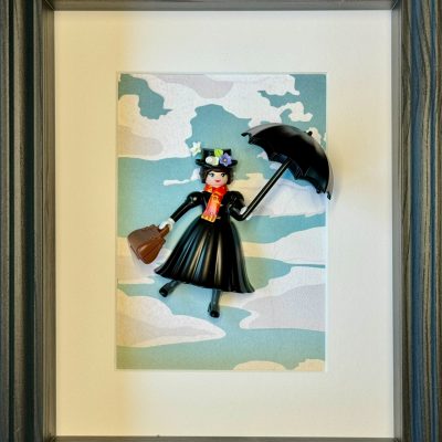 Tableau MARY POPPINS, figurine Playmobil en robe noire tenant un parapluie et un sac, sur fond de nuages, cadre gris