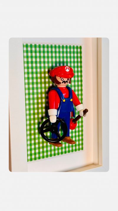 Tableau Super MARIO, figurine Playmobil en salopette bleue et casquette rouge sur fond vichy vert dans un cadre blanc