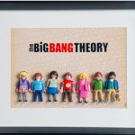 Sept figurines miniatures colorées représentant les personnages de la série The Big Bang Theory, alignées sous un titre en noir et rouge sur fond beige à motifs.