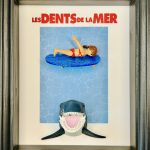 Tableau en figurines playmobil représentant l'affiche du film les dents de la mer avec une femme qui se baigne et en dessous un requin qui s'approche d'elle dangereusement