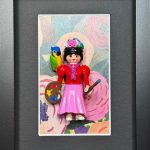 Figurine Playmobil en Frida Kahlo, couronne de fleurs, palette et pinceau, perroquet a l'epaule, sur fond floral encadre