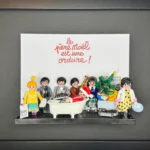 Tableau encadré Le Père Noël est une ordure avec figurines Playmobil autour d'une baignoire et d'un bonnet rouge