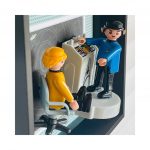 Deux figurines miniatures, l’une en tenue jaune assise sur une chaise de commandement, l’autre en tenue bleue debout près d’un panneau de contrôle avec symboles de la série Star Trek, dans un cadre noir avec un fond étoilé.