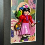 Figurine Playmobil en Frida Kahlo, palette et pinceau, perroquet sur l'epaule, sur fond floral encadre