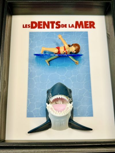 Tableau encadré Les Dents de la mer avec figurine Playmobil sur planche bleue et requin gueule ouverte
