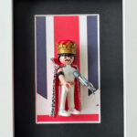 Tableau Freddie Mercury avec figurine Playmobil couronnee et cape sur fond Union Jack, cadre blanc