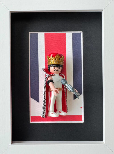 Tableau Freddie Mercury avec figurine Playmobil couronnee et cape sur fond Union Jack, cadre blanc