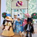 Figurines Playmobil en robes d'époque et haut-de-forme sur un perron, scénographie du tableau Bridgerton