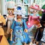 Figurine Playmobil de la Reine Charlotte en robe bleue et perruque fleurie, entourée de dames et d'un petit chien