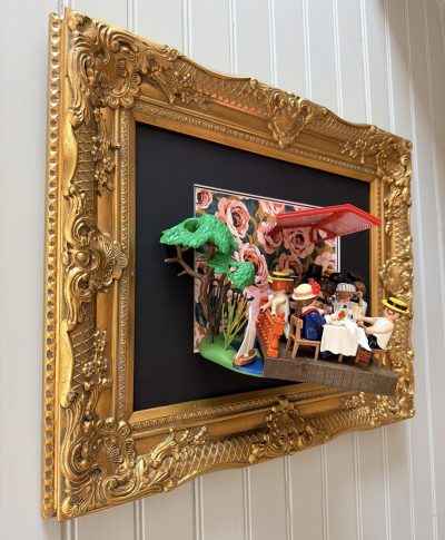 Tableau Le déjeuner des canotiers avec figurines Playmobil attablées sous un store rouge, cadre doré sculpté