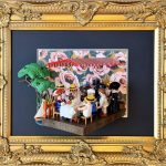 Tableau Le déjeuner des canotiers, figurines Playmobil attablées sous un store rayé, cadre doré et fond fleuri