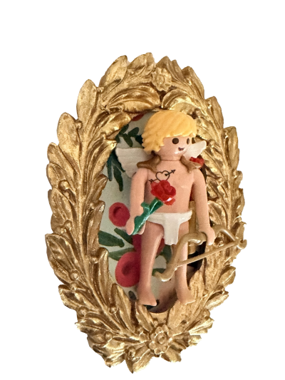 Cupidon blond vu de biais tenant une rose rouge, avec cœur fléché sur le torse, ailes blanches et arc devant un cadre ovale doré.