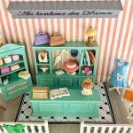 Vue en plongée de la boutique miniature, montrant le comptoir turquoise, le sol noir et blanc, le miroir et le banc fleuri.