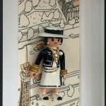 Portrait de Gabrielle Chanel vu de biais, montrant le volume du chapeau, les bijoux et le sac devant la tour Eiffel dessinée.