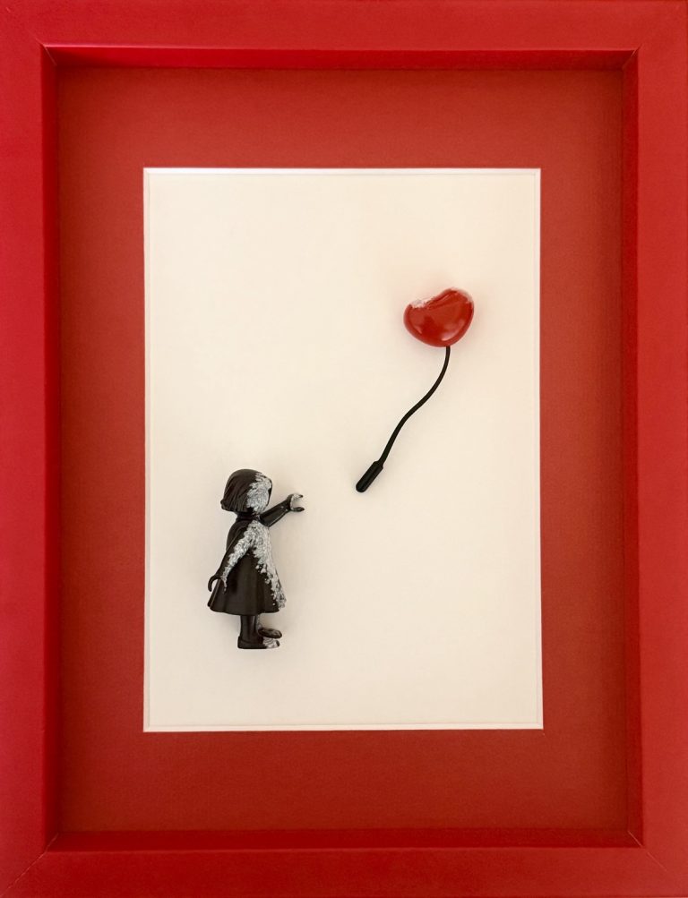 Vue de face du tableau : petite fille noire et ballon cœur rouge dans un cadre rouge.
